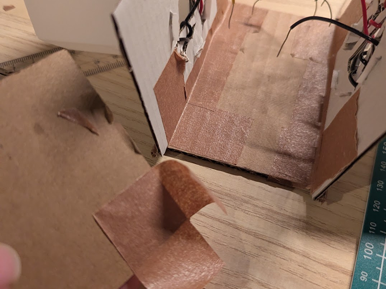 Photo of the main frame being built. Once the walls with the diffusers were built, tape, cut carfully and applied delicatly was used to prevent mess that glue guns can create. It also makes the prototype easier to deconstruct if ever required